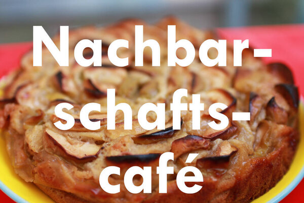 Bild vergr&ouml;&szlig;ern: Nachbarschaftscaf&eacute; steht auf weisse Schrift auf ein Bild von einem Kuchen.